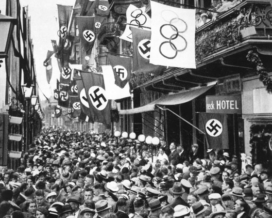 Quando o atleta negro Cornelius Johnson venceu o salto em altura, o chanceler nazista se retirou antes da premiação. Os incidentes teriam resultado em uma advertência do führer pelo Comitê Olímpico Internacional. Na foto: visão geral de multidão nas ruas de Berlim durante os Jogos Olímpicos. Crédito: Getty Images