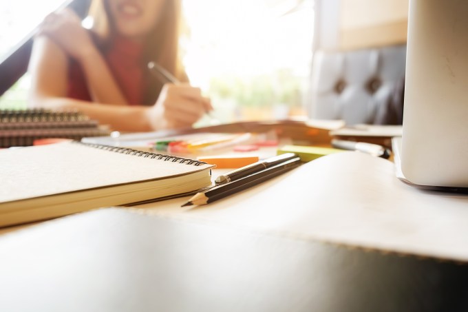Estudante escrevendo em um caderno