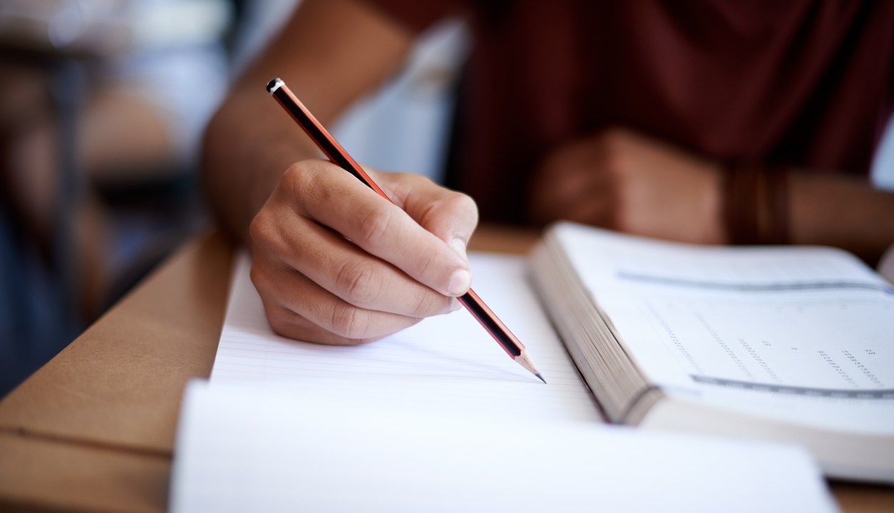 Estudante escrevendo em caderno