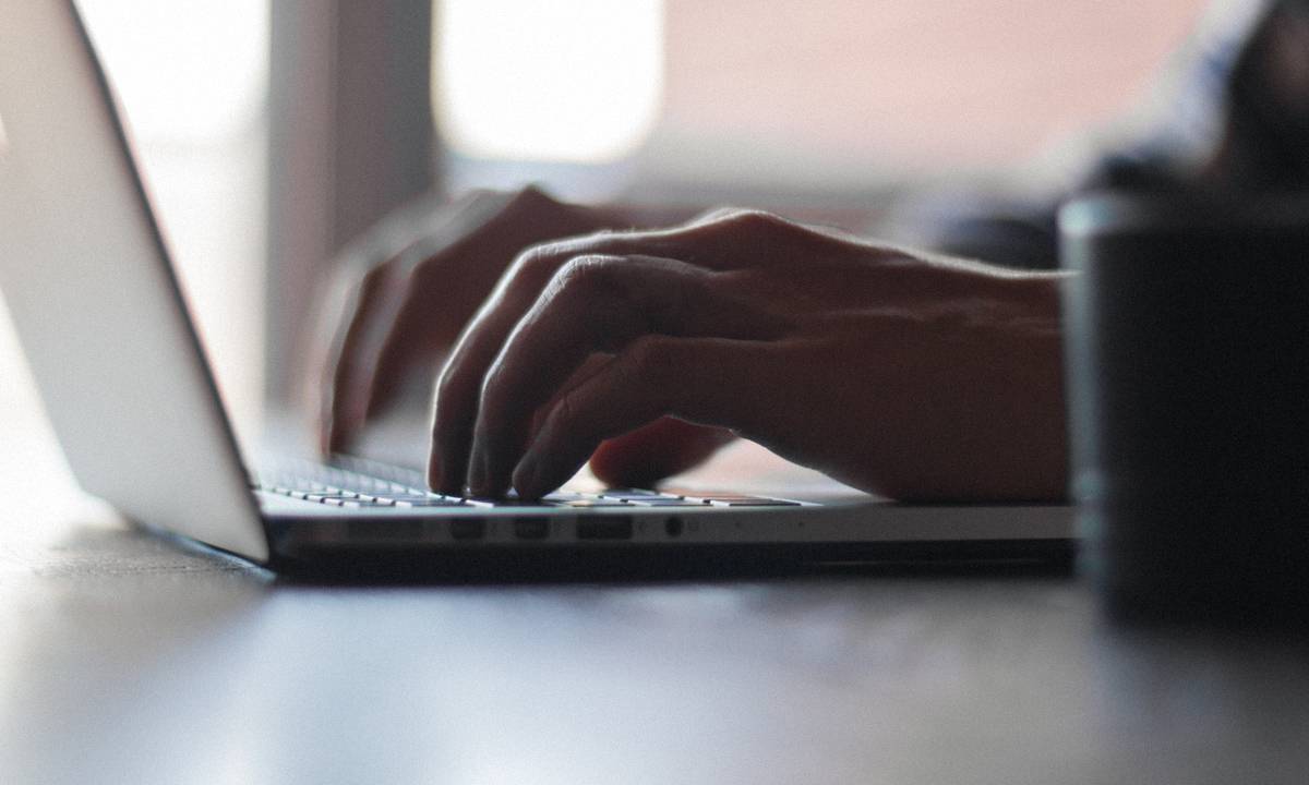 Mãos digitando em um notebook