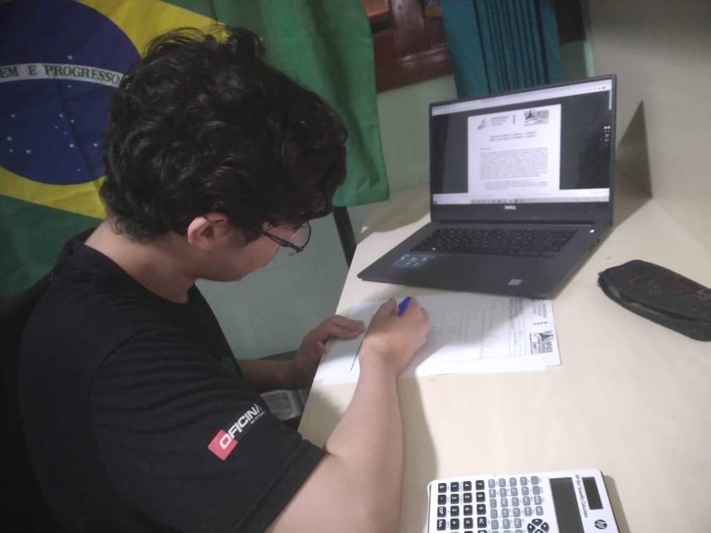 Eduardo Olimpíada Eduardo em frente à sua mesa, com o computador aberto, estudando para uma das etapas da OLAA.