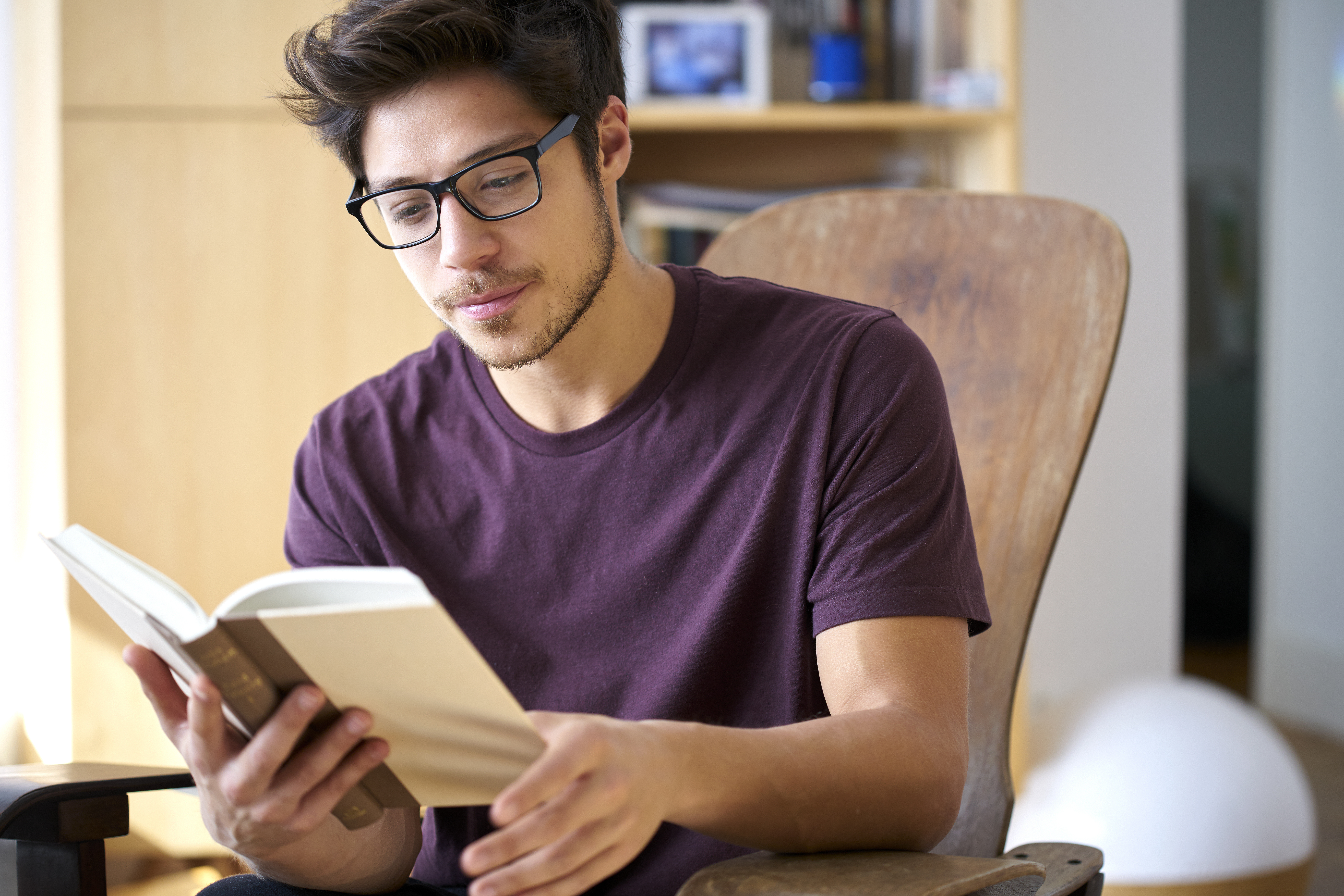 Man sitting in the chair reading a  book