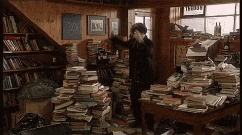Livraria Homem dançando entre pilhas de livros