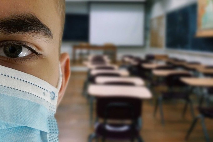 Estudante de máscara em uma sala de aula
