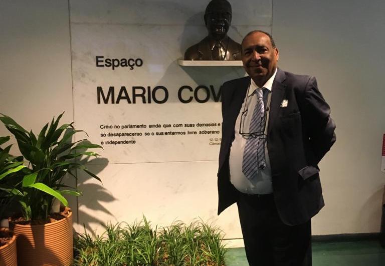 Estudantes mais velhos Homem negro careca usando terno posa em frente a um parede escrita