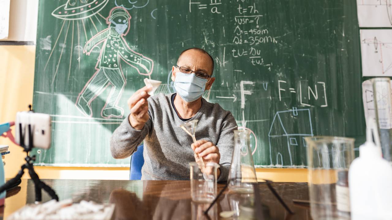 Professor mostrando experimento científico para seus alunos.