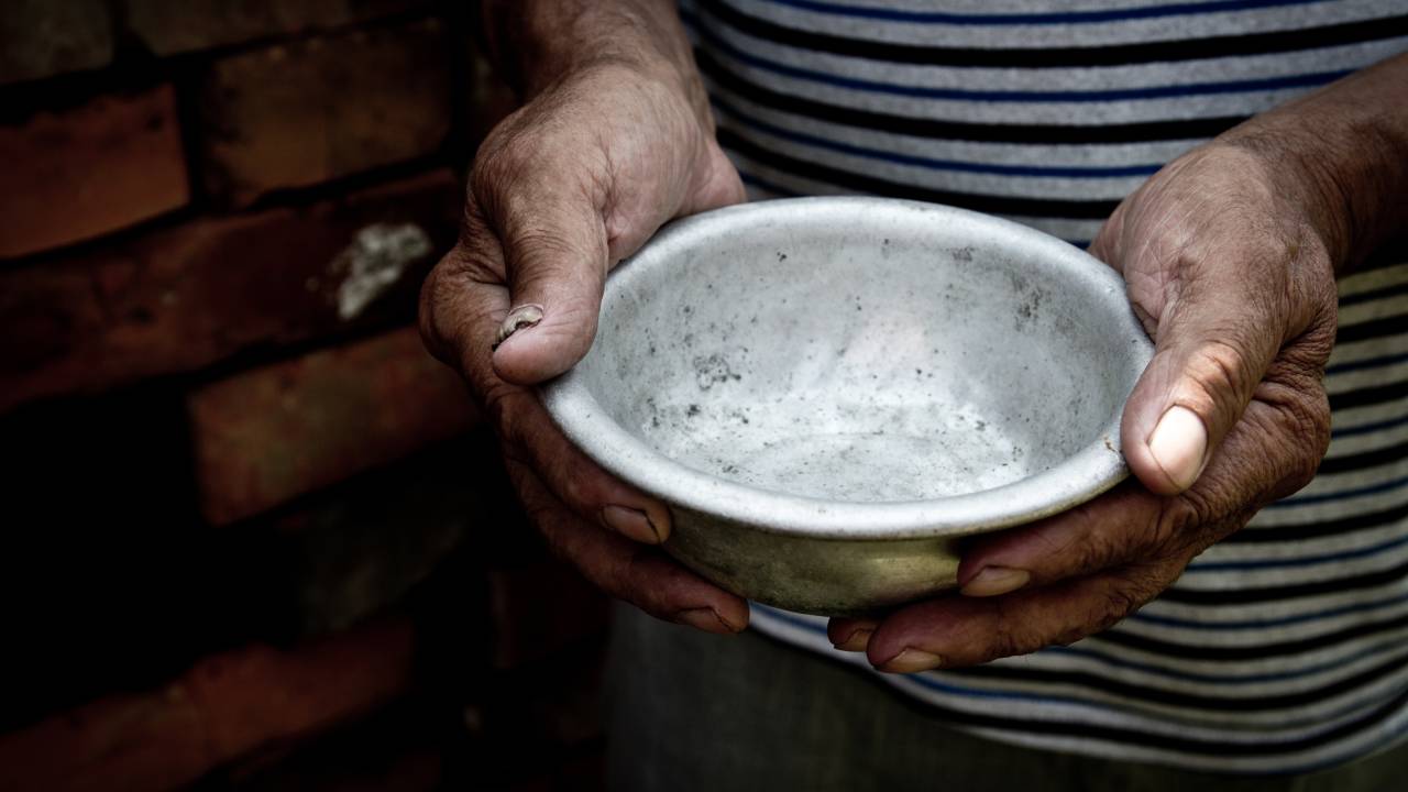 Homem segura prato de comida vazio