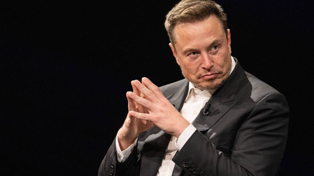 elon musk com os dedos juntos olhando para o lado