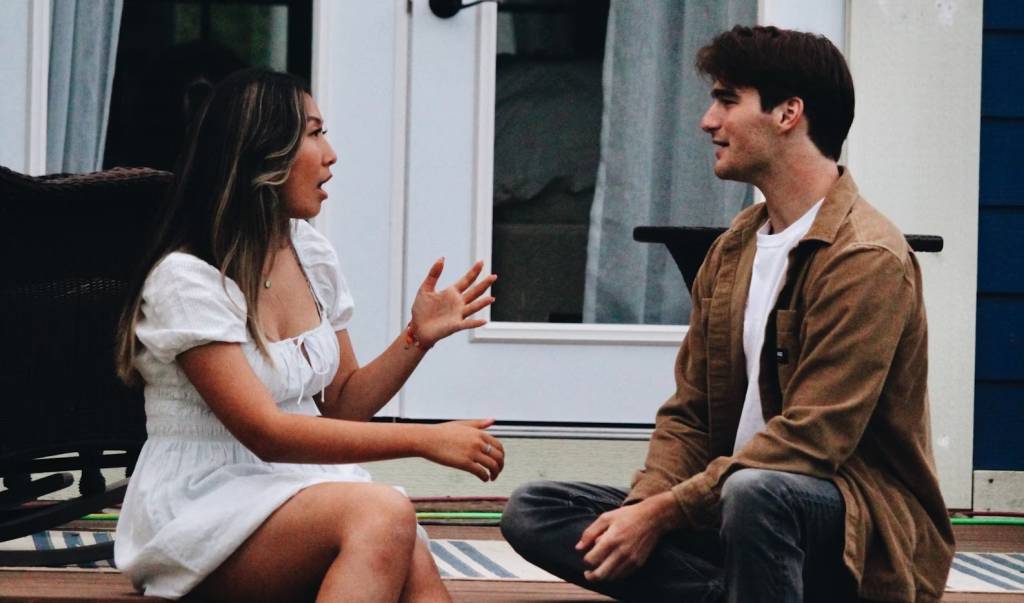 debate homem e mulher conversando; mulher está surpresa
